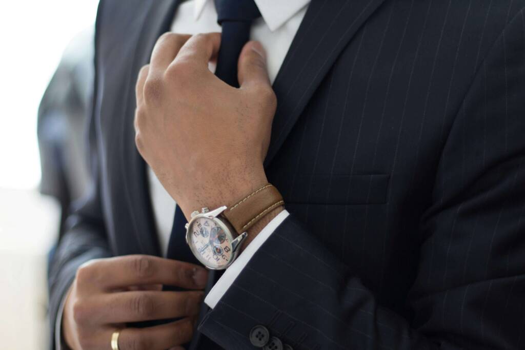 スーツ姿の社会人男性がネクタイを整える様子