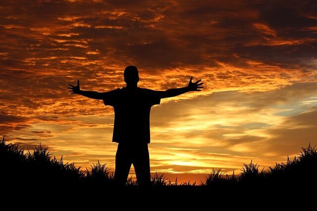 夕日を背景に自由を表現するシルエットの人物