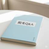「脱毛Q&A」と書かれた水色の本がテーブルに置かれている様子